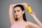 brunette young woman with bare shoulders holding yellow can with soft drink isolated on grey.