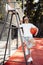 Brunette young woman dressed in casual modern clothes posing with basket ball on referee chair at the stadium.