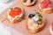 Bruschetta assortment with baguette, cream cheese, red caviar, pickled cheese, salted trout and microgreens