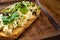 bruschetta with cheese and greens on a wooden cutting board for photos