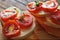 Bruschetta with cherry tomatoes, mozzarella, basil and baguette on a wooden background. Caprese salad.