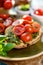 Bruschetta with fresh cherry tomatoes and aromatic herb pesto