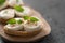 Bruschetta with mozzarella, basil and pesto on olive wood board