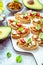 Bruschetta or open ciabatta sandwiches with avocado and tomato spread and feta cheese