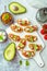 Bruschetta or open ciabatta sandwiches with avocado and tomato spread and feta cheese
