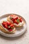 Bruschetta with ricotta, strawberries and basil on light background. Comfort food. Copy space.