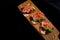 Bruschetta sandwiches with jamon, tomatos, lettuce leaves and green sprouts on wooden board.
