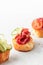 Bruschetta with sausage and vegetables on light gray background. Three of salami sandwiches as appetizer isolated with