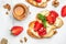 Bruschetta with strawberries, cheese camembert nuts and honey on a light background. Food recipe background. Close up