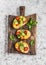 Bruschetta with tomatoes and avocado on rustic wooden cutting board. Delicious snack