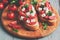 Bruschetta with tomatoes, cheese and cilantro on a cutting wooden board, rustic table. Selective focus, toned image