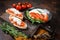 Bruschettas with stracciatella cheese, chopped cherry tomatoes and rosemary. Dark background. Top view