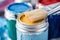 Brush close up on vibrant paint cans, artistic tools and colors