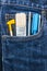 Brush, cutter and screwdriver in blue jean pocket