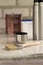 A brush lies next to a plastic paint bucket with a blue lid, a metal can, a thermos with a cup on an old white vintage wooden