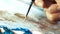 Brush macro close canvas painting. The artist creates. Acrylic and feathering with your finger