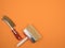 Brush for metal to prepare the surface and a large brush painter. Orange background