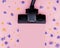 Brush powerful black vacuum cleaner on pink background among flowers. Strength, power, environmental friendliness. Good cleaning,