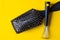 Brush and special tool will help remove tangles and dust stuck between the teeth or bristles. Yellow background. Top view