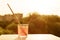 Brushes of the artist in glass with water on wooden white window ledge. Background sky, silhouette of the city, sunset