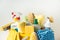 Brushes, bottles with cleaning liquids, sponges, rag and yellow rubber gloves on white background. Cleaning supplies in the yellow