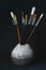 Brushes of different sizes in ceramic crafts, on black background