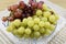 Brushes of fresh grapes of different kinds on a beautiful saucer