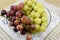 Brushes of fresh grapes of different kinds on a beautiful saucer