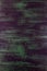 Brushstrokes with thick paint in shades of green, blue, purple on old wooden texture