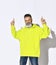 Brutal bearded positive middle aged hipster man in bright yellow hoodie and glasses dancing with fingers up