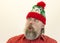 A brutal, bearded, stern man in a red shirt and Santa`s hat. A variety of emotions. Cruelty and masculinity.