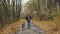 Brutal brunette walking a dog in the autumn park. Self-isolation in nature during an epidemic