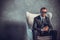 Brutal businessmen in suit with tie and sunglasses sitting on chair