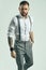 Brutal elegant man in gray classic pants and suspenders isolated