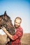 Brutal guy with a beard leads a horse. Farmer in a plaid shirt and