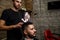 A brutal-looking Barber cuts the hair of an Indian guy. cinematic image