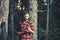 Brutal lumberjack looking at small sharp spade in his hands. Lone hiker in woods. Summer night camping