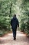 A brutal man in black clothes walks down the alley, back view