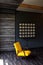 Brutal modern interior in a dark color with a yellow leather chair. Loft style living room