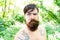Brutal and rugged. Hairy hipster wearing long beard and mustache in brutal style. Bearded man with brutal look on summer