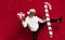 Brutal serious bearded man in santa hat dancing with gift and candy cane