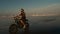 Brutal tattooed biker on ocean coast at sunset