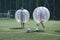 Bubble football. People kicking ball on a football field