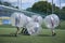 Bubble football. People kicking ball on a football field