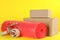 Bubble wrap roll, tape dispenser and cardboard boxes on yellow background