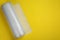 Bubble wrap roll on yellow background, top view. Space for text