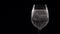Bubbles and bubbling foam of fizzy drink in wine glass over black background