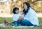 Bubbles, nature and mother with child on a picnic for bonding time together on grass in summer. Happy, love and young