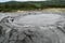 Bubbling crater of a mud volcano. Close up view onto gas bubble exploding in crater of mud volcano. Mud volcano at Paclele Mari,