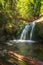 Bubbling foamy waterfalls under wooden bridge.